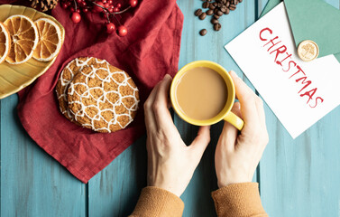 Fototapeta premium Hands, Cup of cappuccino on a Christmas table decorated