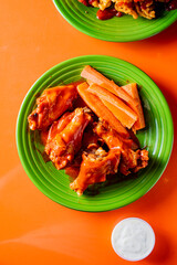 Chicken wings. Chicken wings served spicy buffalo wing sauce and honey barbecue sauce. Served with ranch dressing, blue cheese, celery and carrots. Classic American style bar or pub favorite fare.