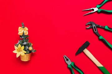 A set of quality green building tools to repair a car or house and Christmas tree on a red background. Do it yourself instruments. Banner for a New year advertise construction shop with copy space