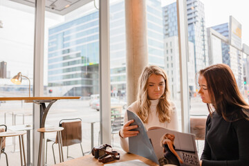 Young Blogger Professionals Discussing Over Publication In Cafe