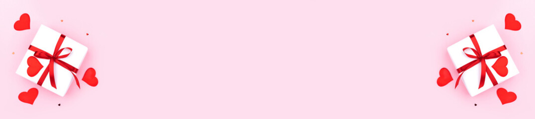 Background with gift, hearts and confetti with free space for text on pastel pink background, wide angle view. Flat lay, top view. Valentines day concept. Mother's Day concept. Banner.