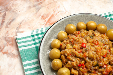 bottom half view roasted eggplant salad and pickled plums on plate on turquoise white checkered tablecloth on nude background