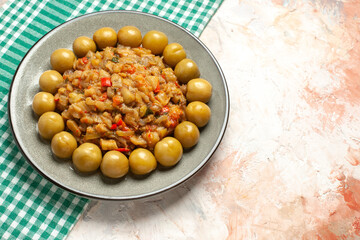 bottom view roasted eggplant salad and pickled plums on plate on turquoise white checkered tablecloth on nude background copy space