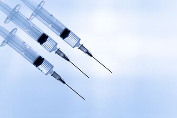 Syringes with liquid on blue background