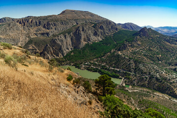Obraz premium Paisaje de montaña con un valle, un embalse, un rio y vegetación típica mediterránea. Desde El Chorro, Álora, Málaga, Andalucía, España.