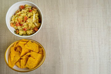 guacamole with tortillas on wooden table