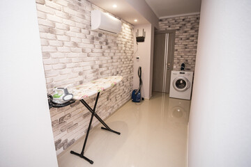 Common area with ironing board, vacuum cleaner and washing machine