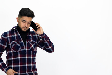 Young man wearing a dark striped shirt.  He has a phone.He has a dirty beard White background. Isolated image. 