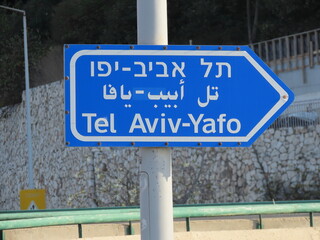 A road sign in Haifa in Israel with the inscription Tel Aviv-Yafo in three languages: English, Arabic, and Hebrew.