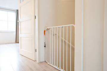 Protective white baby safety stair gate in hallway stairwell modern new house, fence for children...