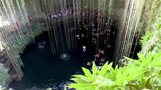 Cenote Ik Kil, Yucatan Mexico. Turists enjoy a swim at cenote Ik Kil in Yucatan, Mexico.