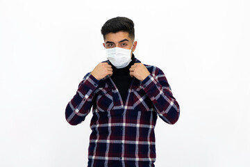 Handsome young man male model. He is wearing a medical mask and a dark checkered shirt.
