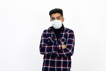 Handsome young man male model. He is wearing a medical mask and a dark checkered shirt.