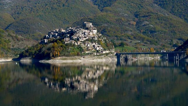 Panoramic view of the Turano lake with Castel di Tora and Colle di Tora reflected in its waters in the province of Rieti in Lazio in Italy.