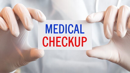 Doctor holding a card with text MEDICAL CHECKUP