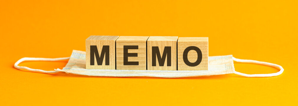 Memo The Word Is Written On Wooden Cubes Lying On A Medical Face Mask, Concept, Yellow Background