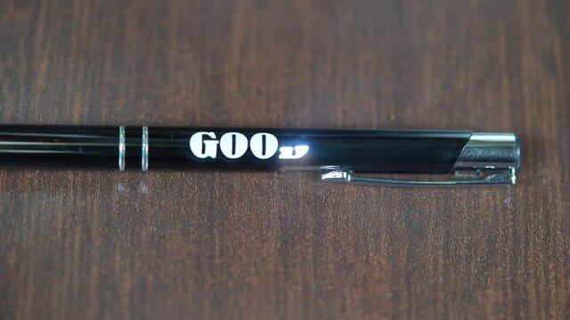 Laser engraving on metal  black pen. Modern industrial technologies. Word Good luck