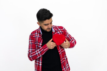 Young man wearing a red striped shirt, holding a heart-shaped gift box in his hand.