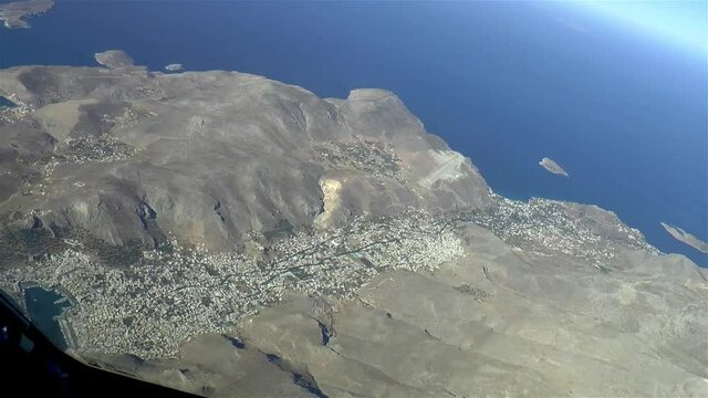 Flying over the Greek Islands. Passenger aircraft climbs over the island of Kalymnos after taking off from the Island of Kos, in Greece. Aerial footage.