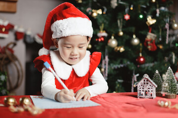 young girl  was writing letter to santa at home