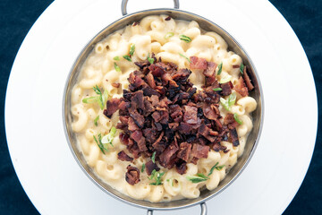Overhead view of bowl of macaroni and cheese with a generous pile of bacon bits for flavor on the top.