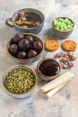 front view cup of tea with plums and candies on light background dessert sweet biscuit