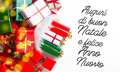 Merry Christmas and happy New Year in italian language holidays card, presents box and gift in the color of the Italian flag Holidays decor background