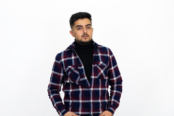 Fototapeta premium Young man posing in the studio. He wears a striped dark shirt.