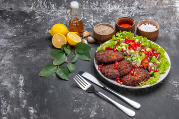 Obraz na płótnie Canvas front view tasty meat cutlets with vegetable salad on grey background photo food meal dish