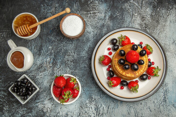 top view yummy pancakes with honey and fruits on light background fruit cake sweet