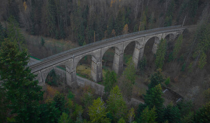 Magical aerial panorama of mystical Glebce viaduct close to Wisla, Poland in late autumn weather. Mysterious train bridge.