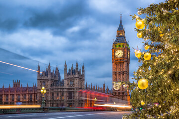 Big Ben with Christmas tree on bridge at night in London, England, United Kingdom