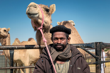 The Traditional Camel Shepherd standing in front of their camel in Al Sarar desert area -Saudi Arabia. 17-Jan-2020.