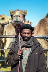 The Traditional Camel Shepherd standing in front of their camel in Al Sarar desert area -Saudi Arabia. 17-Jan-2020.