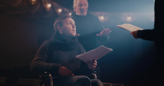 Elderly director giving instructions to actors during rehearsal