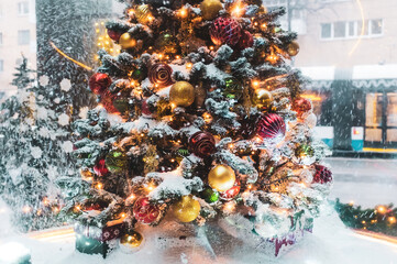 A Christmas tree with gifts underneath, covered with freshly fallen snow.