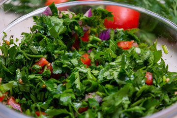 Close up on Tabbouleh salad made with parsley, cherry tomatoes, onion, lemon, olive oil and basil