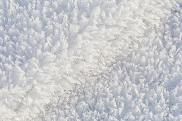 Winter, snow and frost, surface structure of a winter landscape with large crystals, space texture, white background.