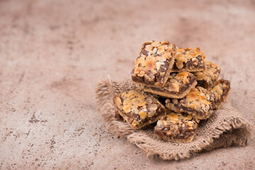 Confectioneries with nuts and chocolate, german christmas sweets, little cakes on a brown textured background, empty copy space for text