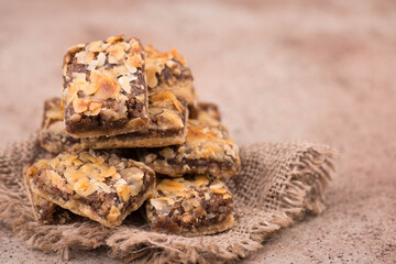 Confectioneries with nuts and chocolate, german christmas sweets, little cakes on a brown textured background, empty copy space for text