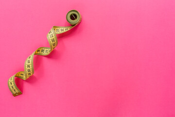 Measure tape on pink background. Diet and weight loss concept.. Flat lay, top view, copy space