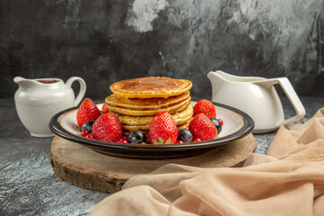 front view yummy pancakes with fruits and honey on light background sweet fruit milk