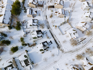 Obraz na płótnie Canvas Aerial down view to on covered houses and roads at winter season courtyards covered snow with snow
