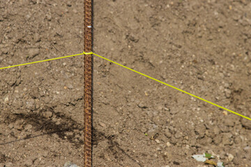 Construction rebar in the process of preparing the Foundation construction with a yellow leveling rope.