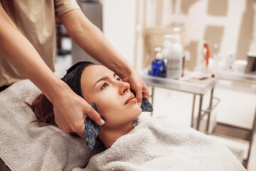Obraz na płótnie Canvas Woman receiving facial massage in beauty salon.