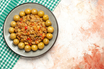 top view roasted eggplant salad and pickled plums on plate on turquoise white checkered tablecloth on nude background copy place
