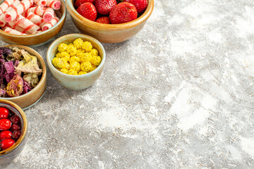 front view fresh red strawberries with candies on a white background fruit sweet candy color