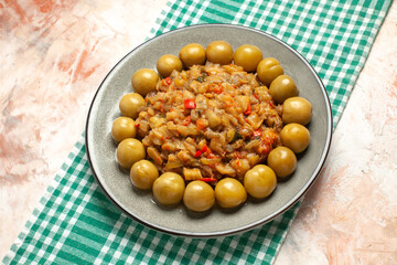 bottom view roasted eggplant salad on plate on nude background