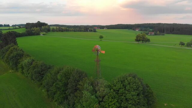 Drone shot rotating a old wind turbine at dusk