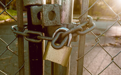 Locked Gate Tethered by metal chain and old rusty padlock.